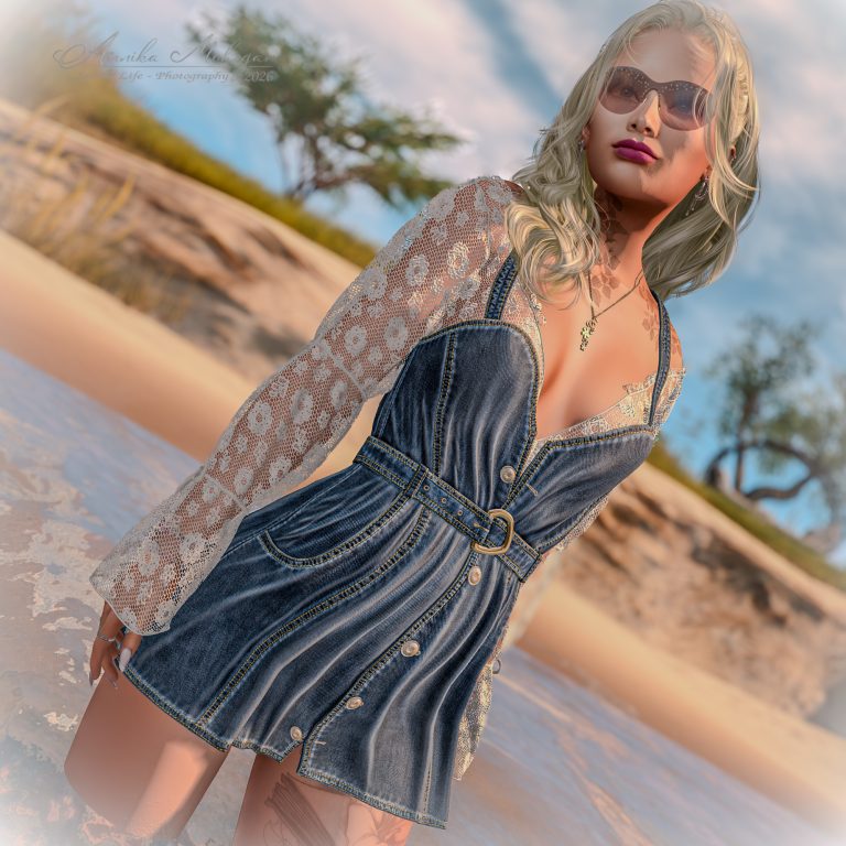 Annika in ganzer Figur am Strand von Le Monde Perdu – Denimkleid Celine von adorsy über cremefarbenem Spitzentop, langes blondes Haar und getönte Sonnenbrille