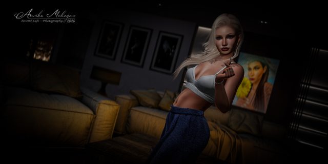 Annika Mohegan im Aaliyah-Look von TORI TORRICELLI: weißes Bralette-Top und dunkelblaue Stoffhose, fotografiert bei warmem Lampenlicht in Second Life